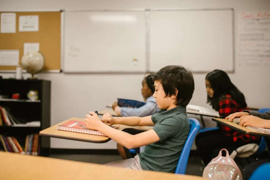 Bambino che usa il cellulare in classe