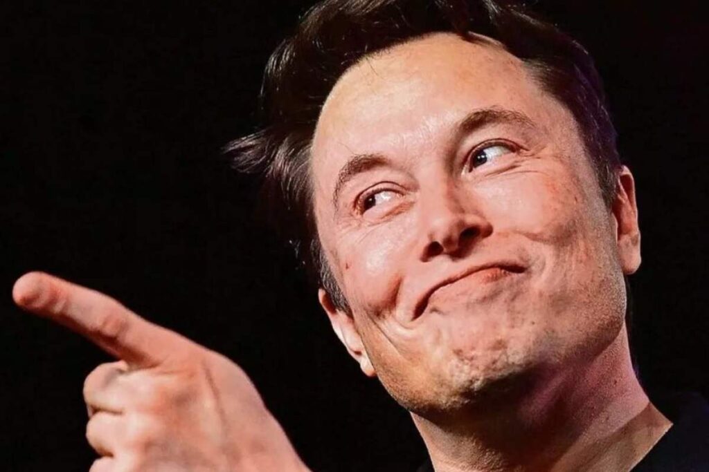 Elon Musk che sorride beffardo e punta il dito