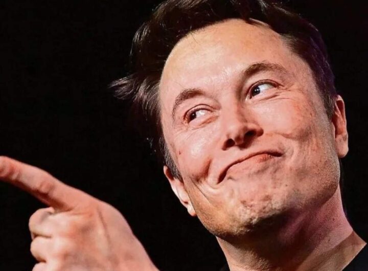 Elon Musk che sorride beffardo e punta il dito