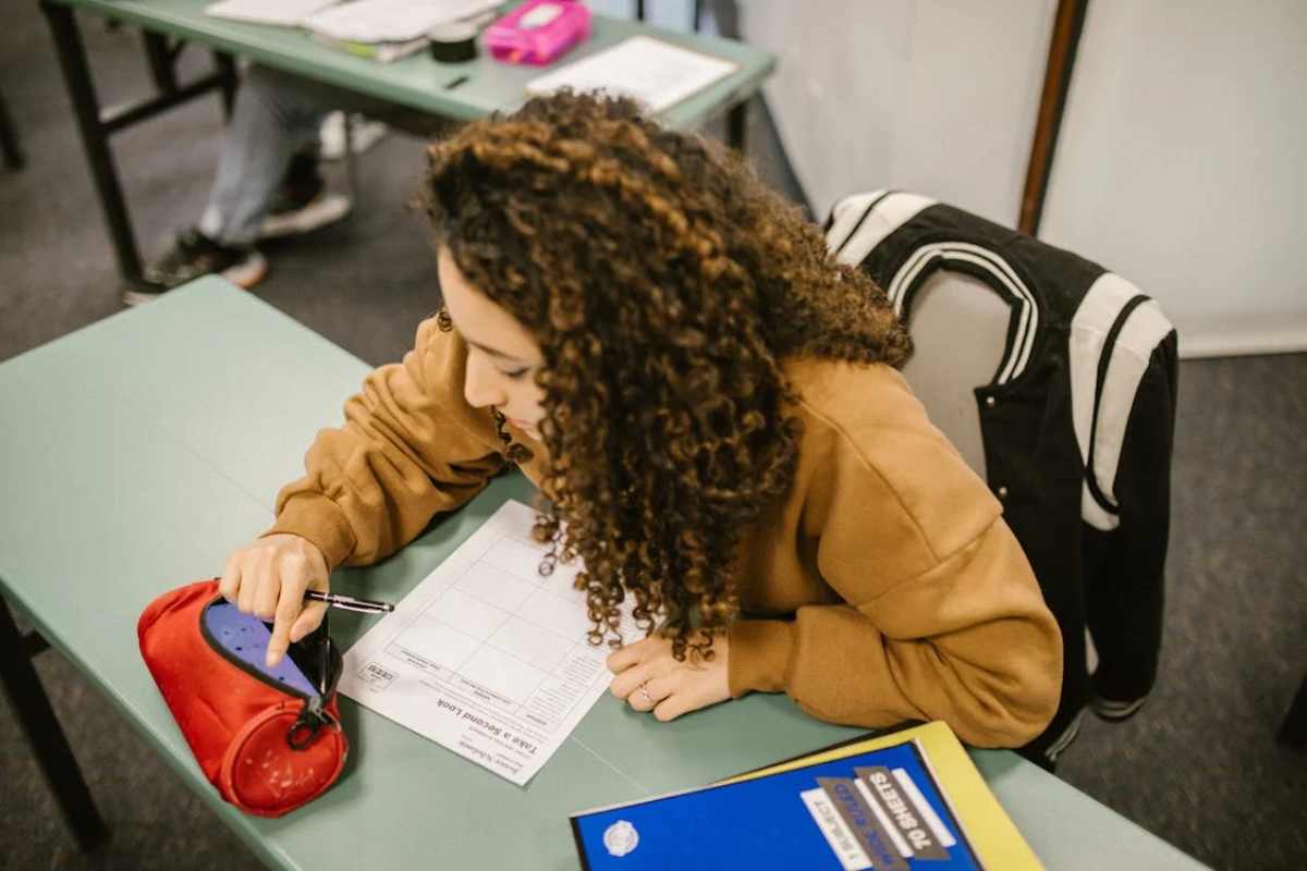 Ragazza che si distrae con cellulare in classe