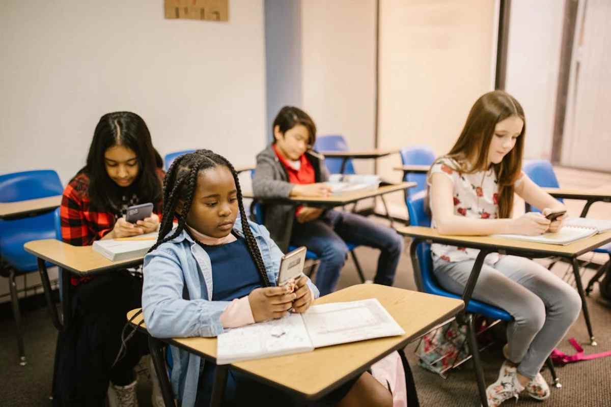 bambine in classe con il cellulare in mano