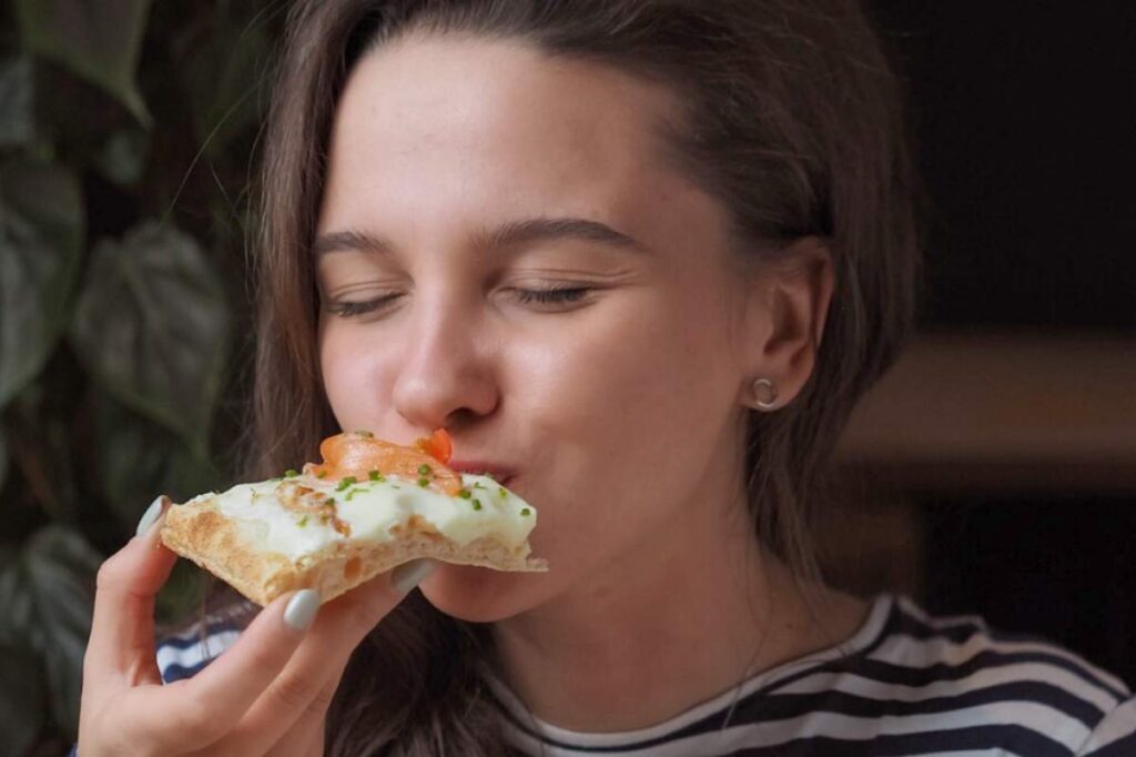 ragazza che mangia una pizza di gusto