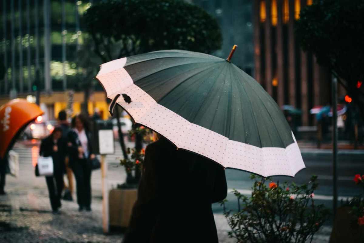 persona con ombrello sotto la pioggia